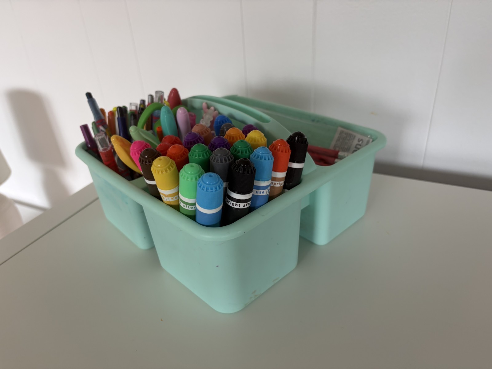 Kids craft table with crayons and art supplies — where the tug-of-war starts